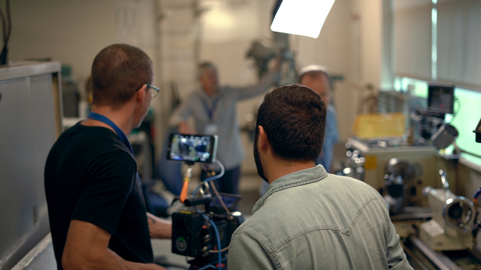 Behind the scenes shot of John Long and Joe Clay looking at the monitor of a cinema camera while blocking a shot at LifeLink headquarters in Tampa, Florida.