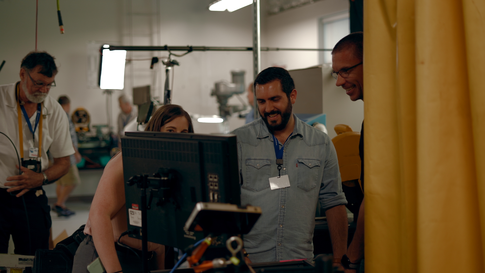 Behind the scenes shot of Michael Stahr, Ashley Moore, Joe Clay, and John Long on set looking at a monitor at LifeLink headquarters in Tampa, Florida.