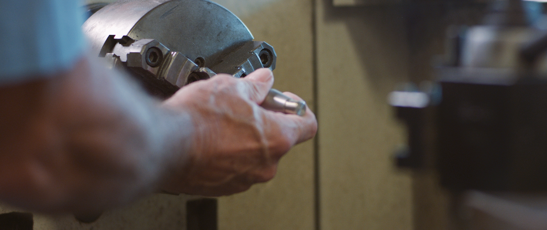 A man chucks a piece of metal into a lathe at LifeLink headquarters in Tampa, Florida.
